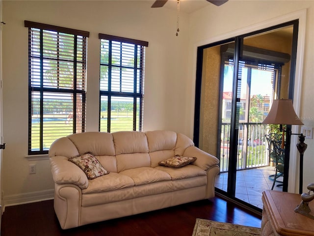 living room featuring ceiling fan and dark wood-type flooring