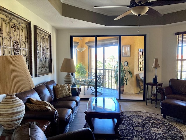 living room with tile patterned floors, a wealth of natural light, ceiling fan, and crown molding