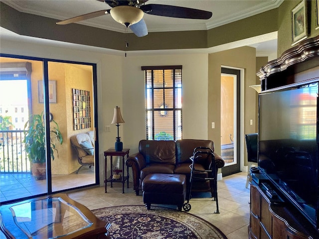 tiled living room featuring a healthy amount of sunlight, a raised ceiling, crown molding, and ceiling fan