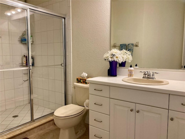 bathroom with tile patterned flooring, a shower with door, toilet, and vanity