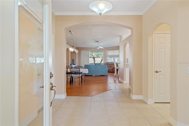 hall with ornamental molding and light tile patterned floors