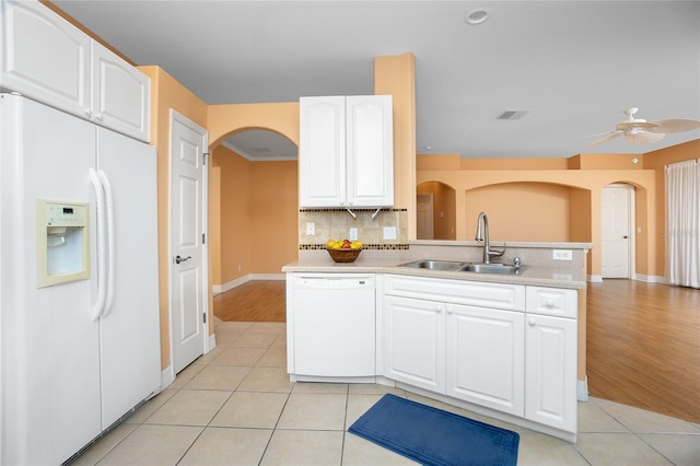 kitchen featuring sink, light tile patterned floors, white appliances, decorative backsplash, and white cabinets