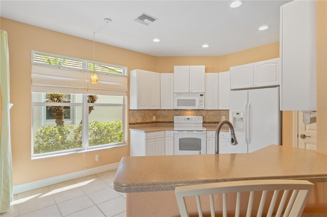 kitchen featuring white cabinetry, hanging light fixtures, white appliances, and tasteful backsplash