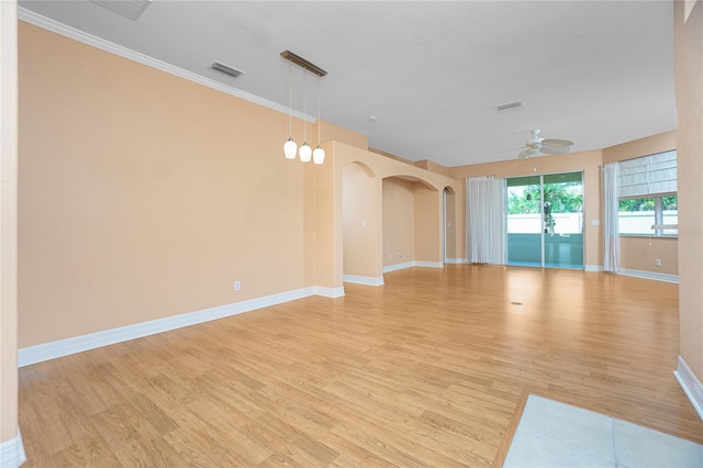 empty room featuring ceiling fan, ornamental molding, and light wood-type flooring