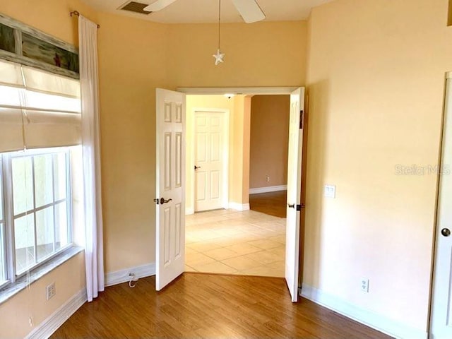 empty room with ceiling fan and wood-type flooring