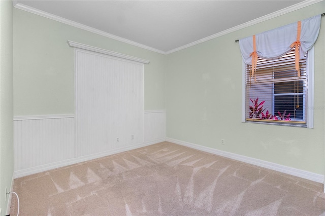 empty room featuring crown molding and carpet floors