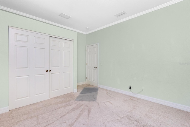 unfurnished bedroom with light carpet, ornamental molding, and a closet