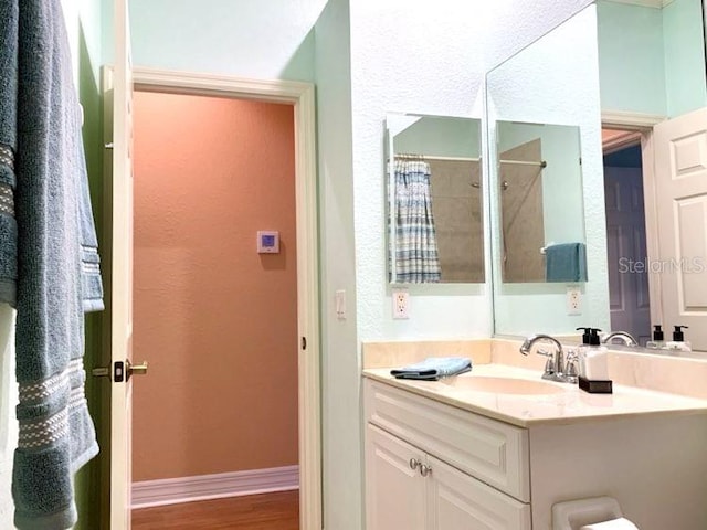 bathroom with a shower with shower curtain, vanity, and hardwood / wood-style floors