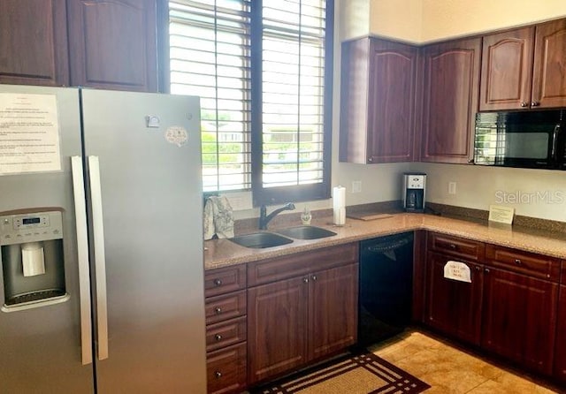 kitchen with sink, light tile patterned floors, and black appliances