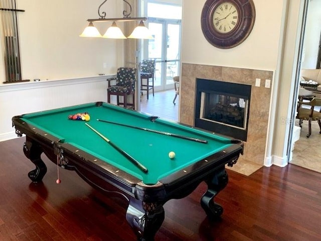 game room featuring french doors, billiards, dark hardwood / wood-style flooring, and a tile fireplace