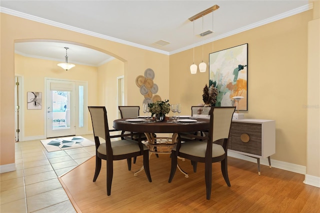 tiled dining area featuring crown molding