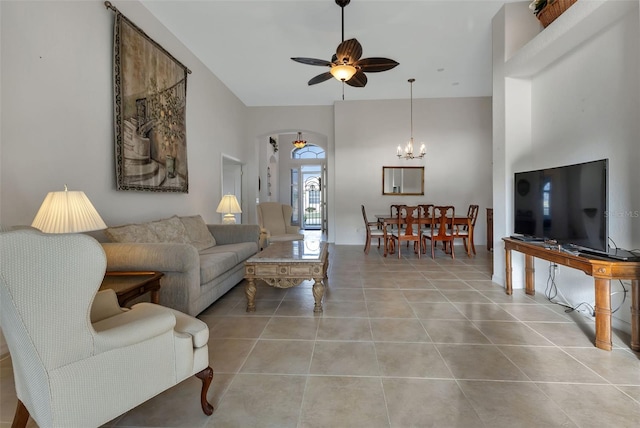 living room with light tile flooring and ceiling fan with notable chandelier