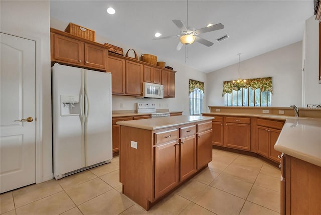 kitchen with white appliances, light tile floors, a kitchen island, vaulted ceiling, and ceiling fan with notable chandelier