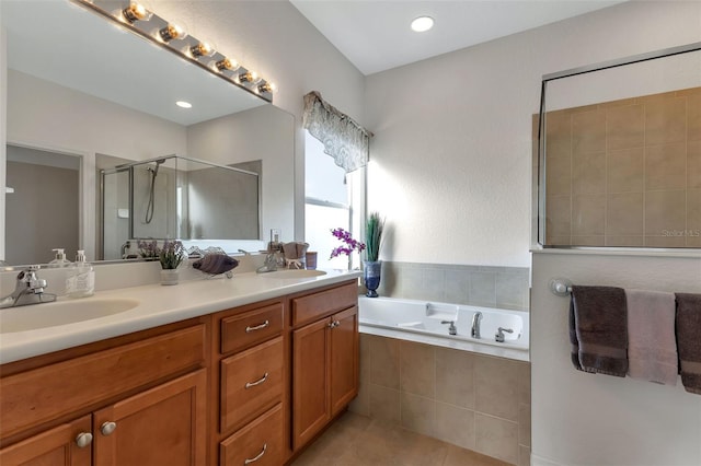 bathroom with double sink vanity, shower with separate bathtub, and tile floors