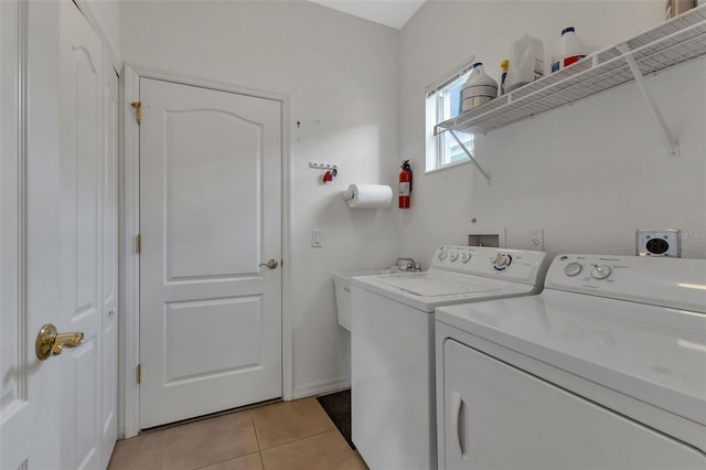 washroom featuring hookup for a washing machine, light tile floors, hookup for an electric dryer, and washing machine and clothes dryer