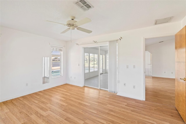 empty room with ceiling fan and light hardwood / wood-style floors