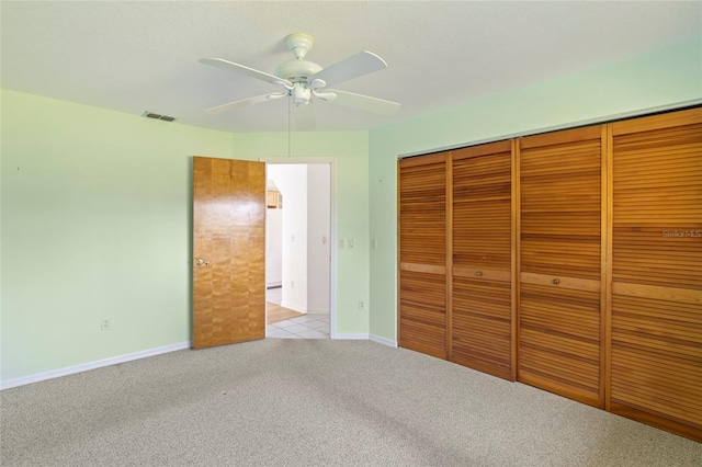 unfurnished bedroom with ceiling fan, a closet, and light carpet