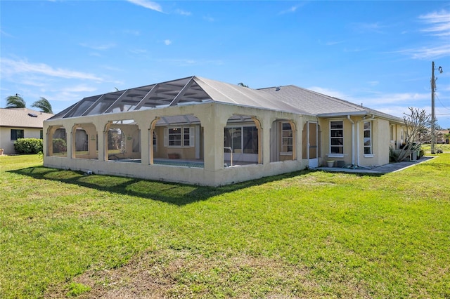 rear view of property with glass enclosure and a yard