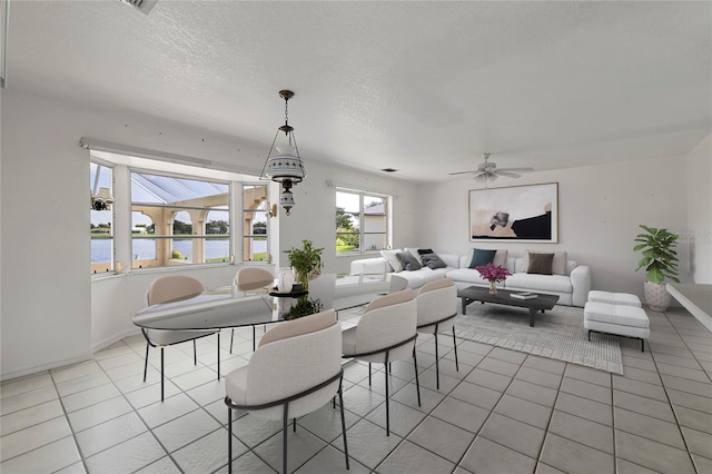 dining area featuring light tile patterned flooring, ceiling fan, and a textured ceiling