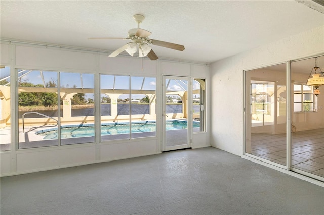 unfurnished sunroom with ceiling fan