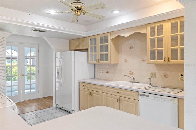 kitchen featuring backsplash, sink, light hardwood / wood-style flooring, white appliances, and ceiling fan