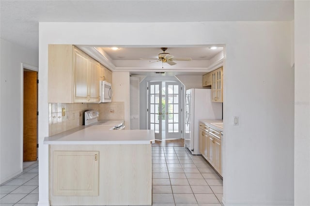 kitchen with ceiling fan, a raised ceiling, stainless steel range with electric cooktop, light tile patterned floors, and kitchen peninsula