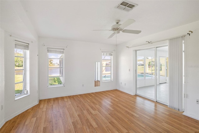 spare room featuring a wealth of natural light, ceiling fan, and light hardwood / wood-style floors