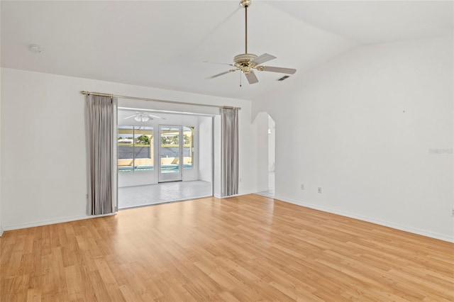 empty room with ceiling fan, vaulted ceiling, and light hardwood / wood-style flooring