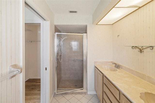 bathroom with wood-type flooring, an enclosed shower, and vanity