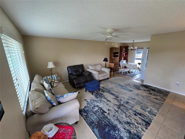 21427 Michigan Ave, Port Charlotte, FL 33952 - living area with tile patterned flooring, a ceiling fan, a textured ceiling, and a chandelier