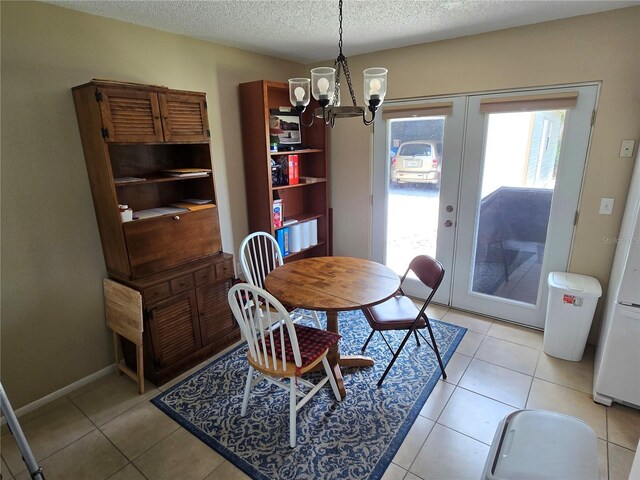 21427 Michigan Ave, Port Charlotte, FL 33952 - dining area with a chandelier, healthy amount of natural light, french doors, a textured ceiling, and light tile patterned floors