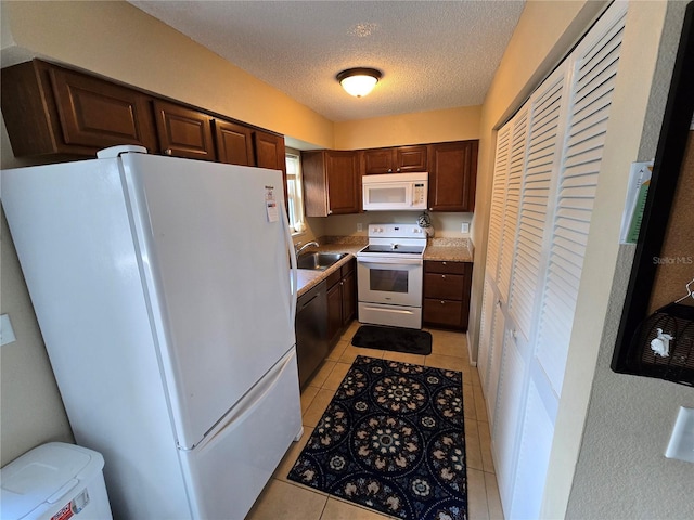 21427 Michigan Ave, Port Charlotte, FL 33952 - kitchen featuring white appliances, light countertops, light tile patterned floors, a textured ceiling, and dark brown cabinetry