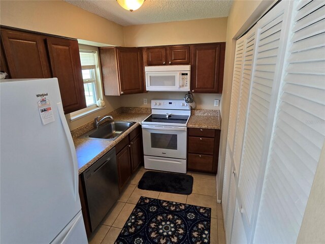 21427 Michigan Ave, Port Charlotte, FL 33952 - kitchen featuring white appliances, a textured ceiling, light tile patterned floors, and light countertops