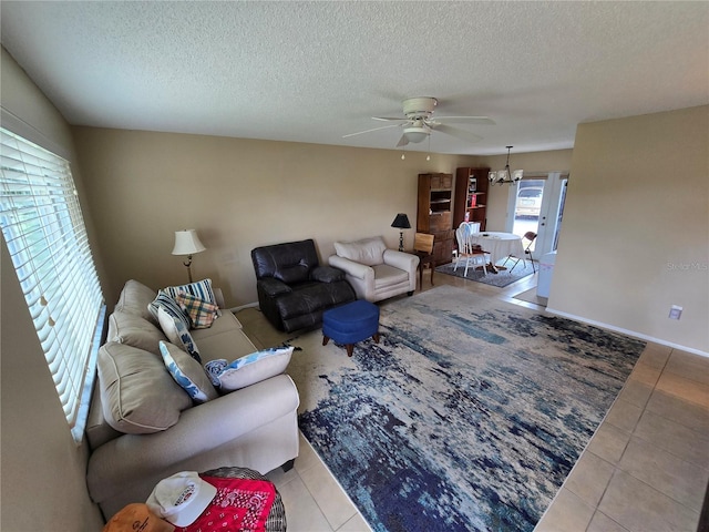 21427 Michigan Ave, Port Charlotte, FL 33952 - living room with a ceiling fan, light tile patterned floors, a chandelier, and a textured ceiling