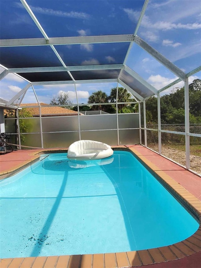 view of swimming pool featuring a lanai