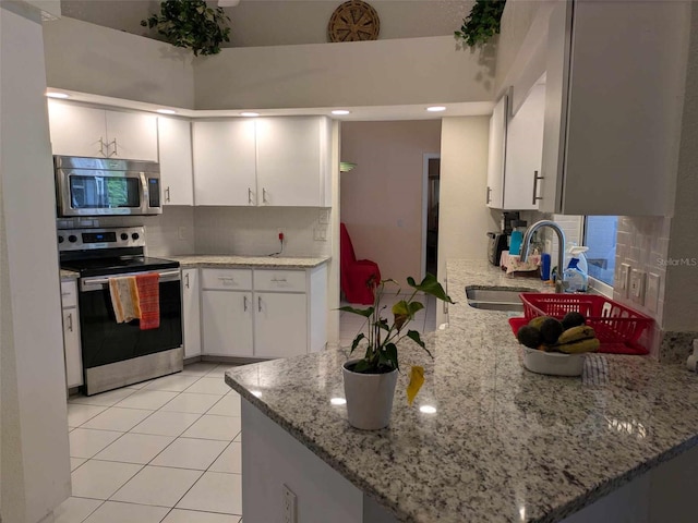 kitchen featuring sink, decorative backsplash, light stone counters, and stainless steel appliances