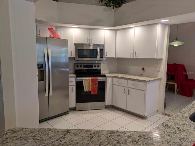 kitchen with white cabinets, light tile patterned floors, backsplash, and stainless steel appliances