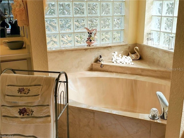 bathroom featuring a tub to relax in and a wealth of natural light