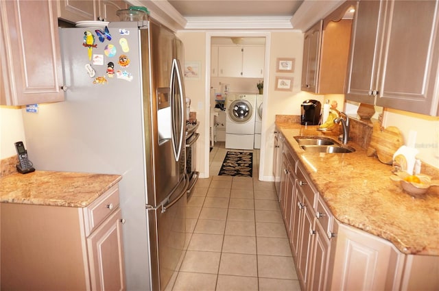 kitchen with light tile floors, washer and clothes dryer, light stone counters, and sink