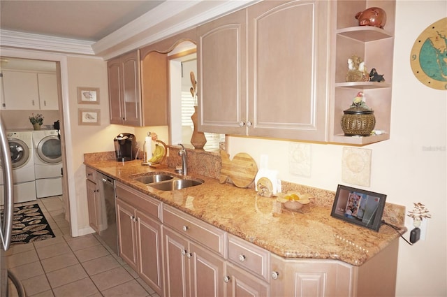 kitchen with stainless steel dishwasher, light tile floors, light stone countertops, washing machine and clothes dryer, and sink