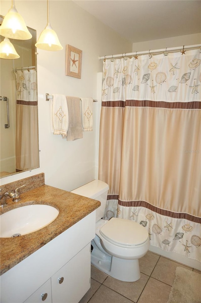 bathroom featuring toilet, tile floors, and oversized vanity