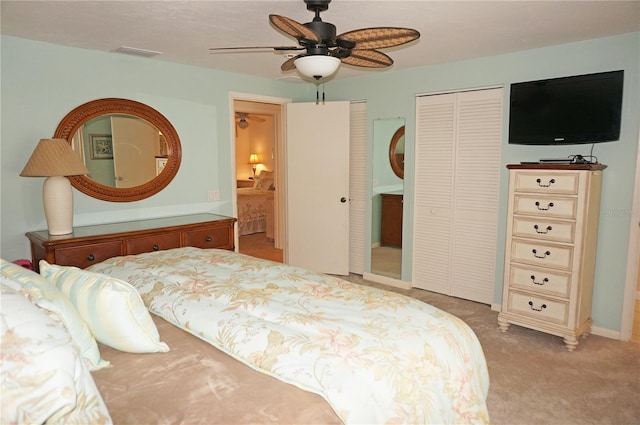 bedroom with multiple closets, ceiling fan, and light colored carpet