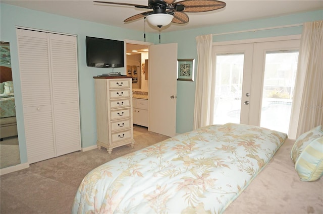 carpeted bedroom featuring a closet, ceiling fan, access to exterior, ensuite bath, and french doors