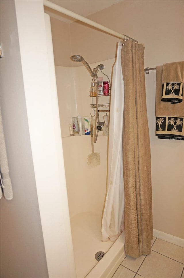 bathroom featuring curtained shower and tile flooring