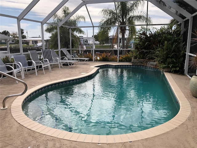 view of swimming pool featuring a patio area and glass enclosure