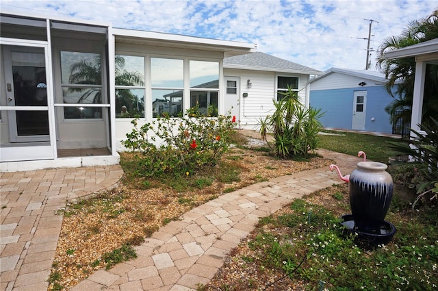 back of property with a sunroom