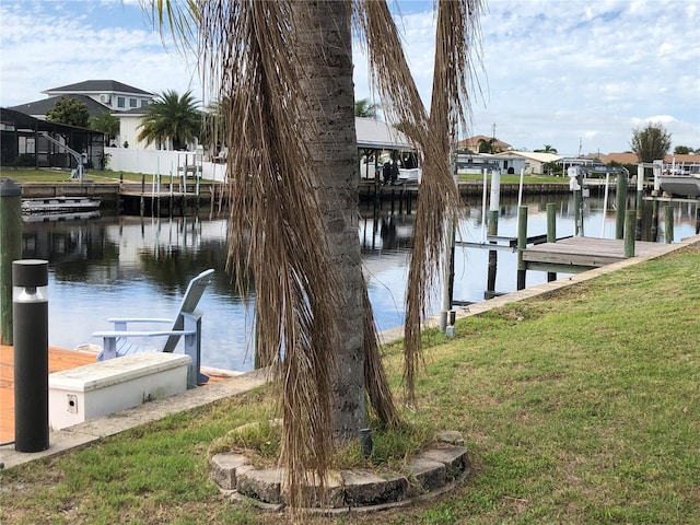 view of dock featuring a water view and a yard