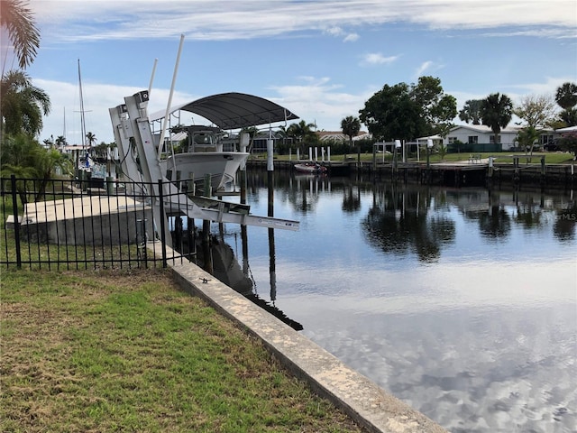 view of dock with a lawn and a water view