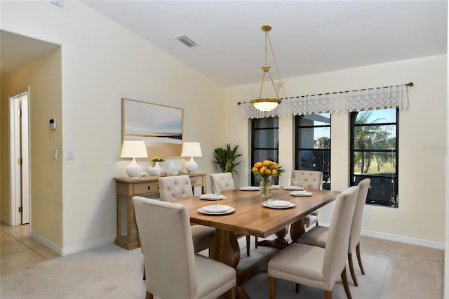 carpeted dining room featuring lofted ceiling