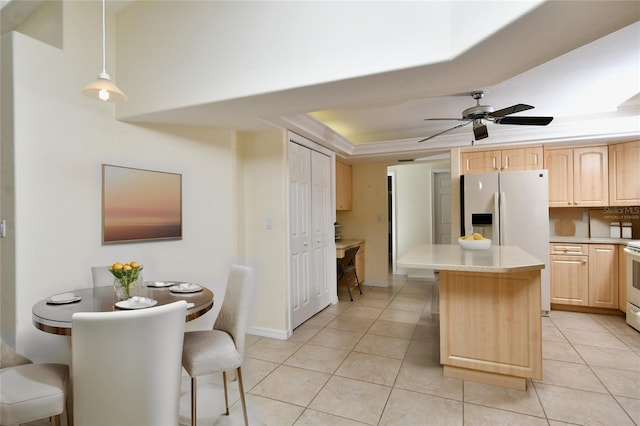 kitchen with decorative light fixtures, light tile flooring, ceiling fan, and a breakfast bar